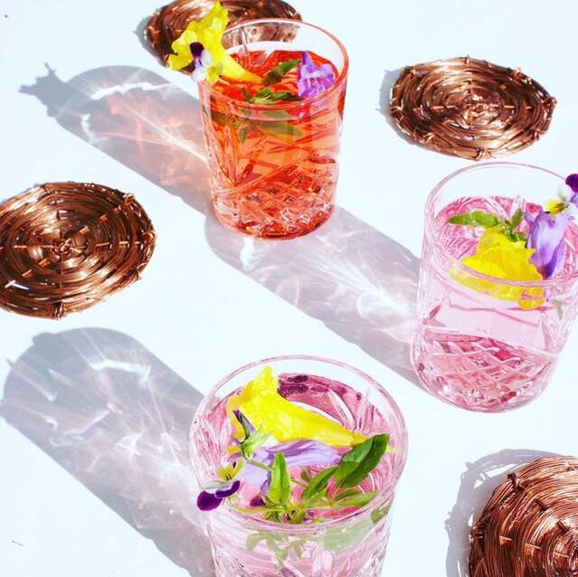 Beautiful cocktails with edible garnishes served on bespoke coasters