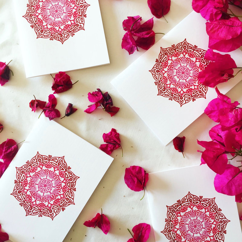Pink gift cards styled with fresh, pink flowers and white fabric